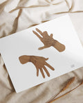 Illustration of two brown hands in expressive poses on white paper with fabric background